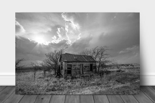 Black and white metal print on aluminum of an abandoned house as sunshine breaks through storm clouds on the Kansas prairie by Sean Ramsey of Southern Plains Photography.