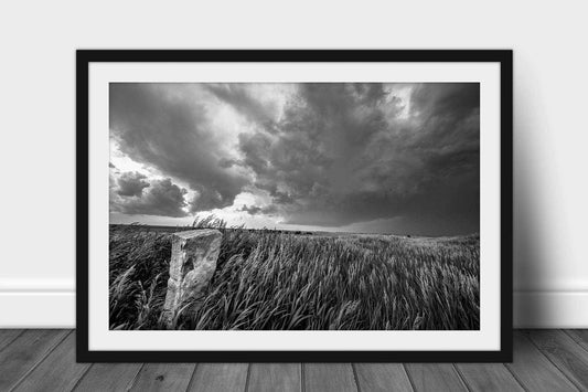 Framed and matted print in black and white of a limestone marker in prairie grass as a storm brews on the horizon in Kansas by Sean Ramsey of Southern Plains Photography.