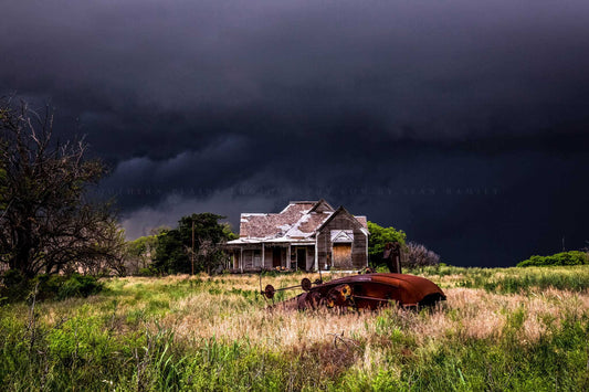 Moody storm photography print of an abandoned house and classic cotton gin under a dark stormy sky on a spring evening in Texas by Sean Ramsey of Southern Plains Photography.