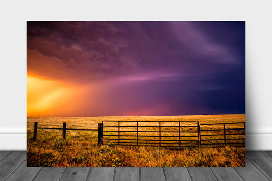 Western aluminum metal print wall art of a colorful sky over a fence gate on a stormy summer evening in Oklahoma by Sean Ramsey of Southern Plains Photography.