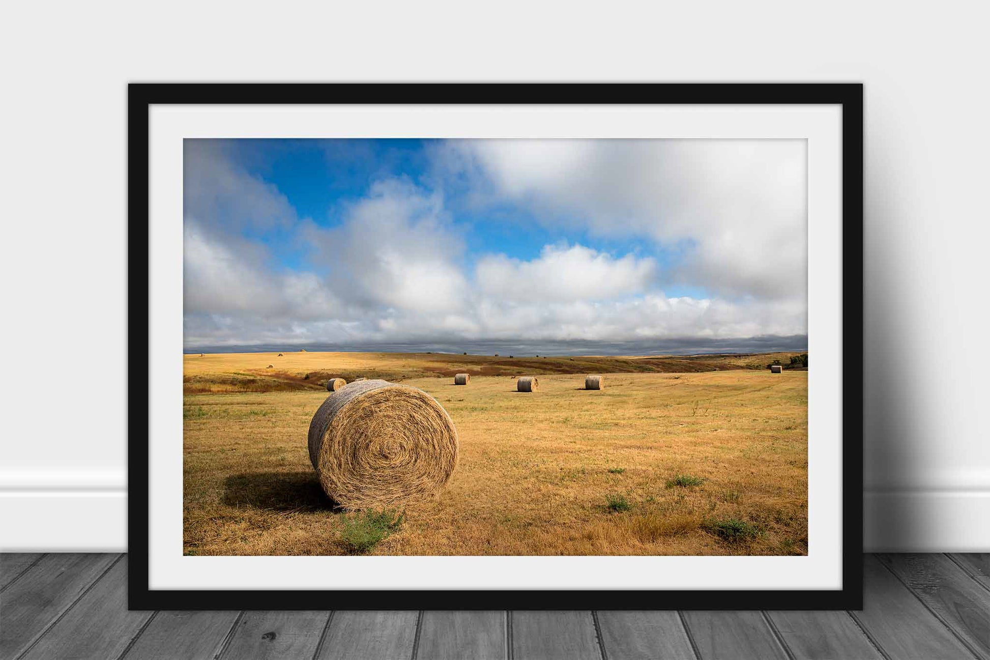 Framed and matted prairie photography print of round hay bales under a fair sky on the Pine Ridge Reservation in South Dakota by Sean Ramsey of Southern Plains Photography.