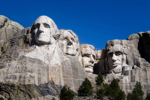Travel photography print of George Washington, Thomas Jefferson, Theodore Roosevelt and Abraham Lincoln under a bluebird sky at the Mount Rushmore National Memorial in the Black Hills of South Dakota by Sean Ramsey of Southern Plains Photography.