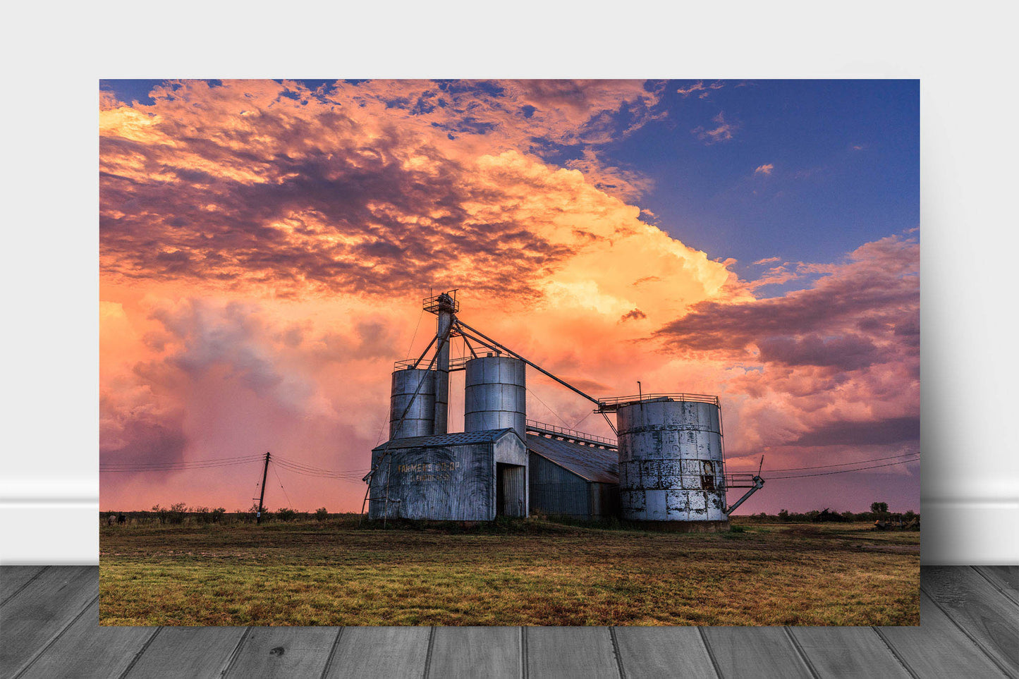 Farm and country aluminum metal print wall art of grain silos under a colorful stormy sky at sunset in a rural small town in Texas by Sean Ramsey of Southern Plains Photography.