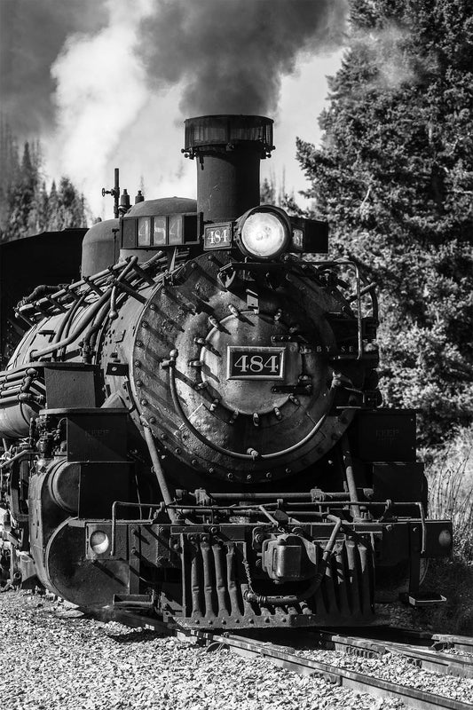 Vertical black and white train photography print of a vintage style steam engine rolling down the tracks along a railroad in the mountains of Colorado by Sean Ramsey of Southern Plains Photography.