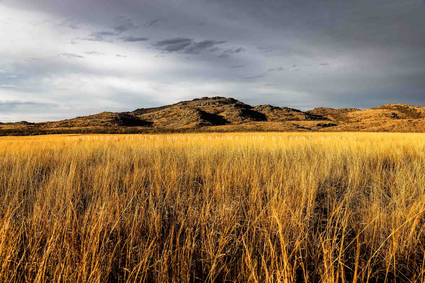 Landscape photography print of the Wichita Mountains overlooking golden prairie grass on a late autumn day at the Wichita Mountains Wildlife Refuge in Oklahoma by Sean Ramsey of Southern Plains Photography.
