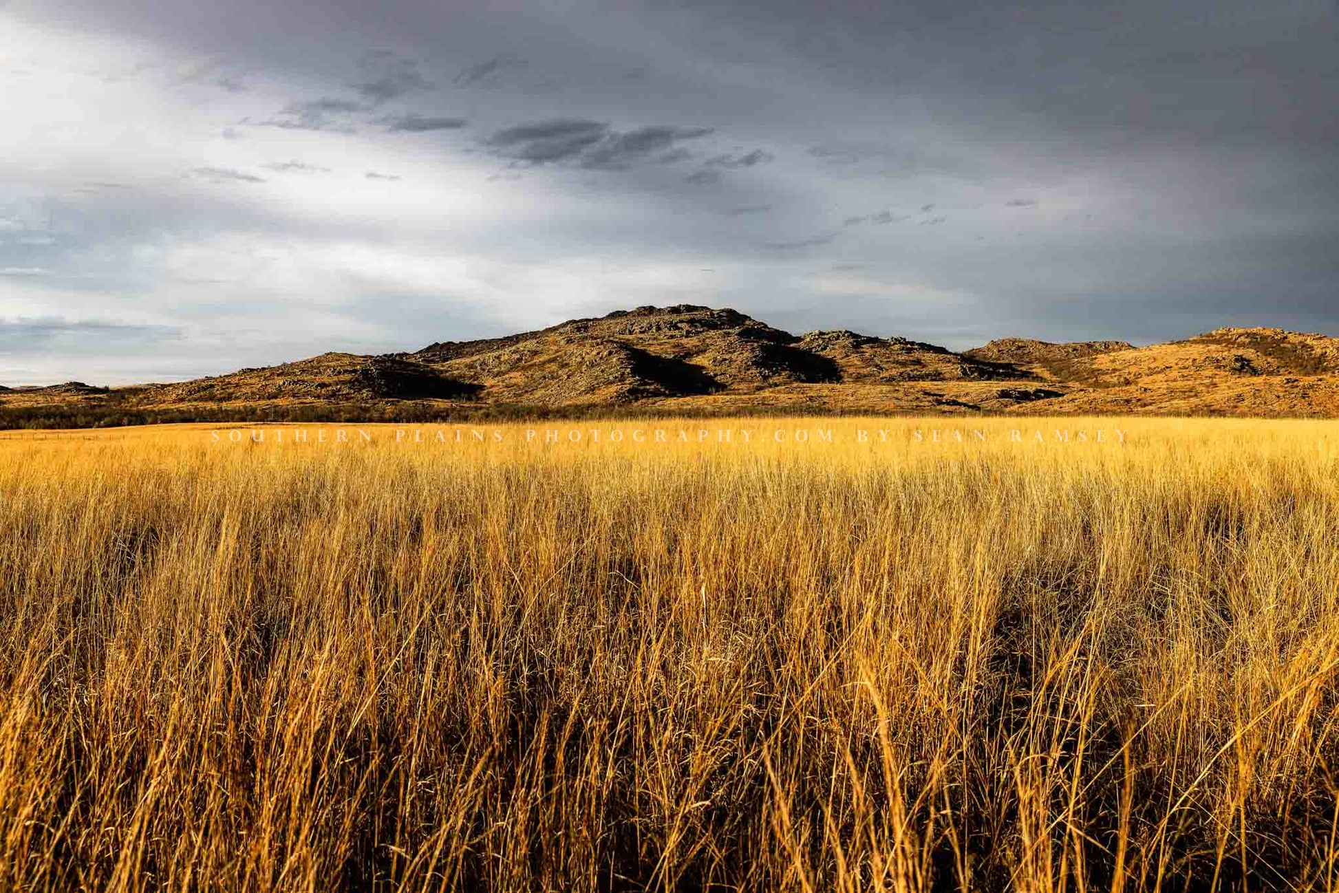 Landscape photography print of the Wichita Mountains overlooking golden prairie grass on a late autumn day at the Wichita Mountains Wildlife Refuge in Oklahoma by Sean Ramsey of Southern Plains Photography.