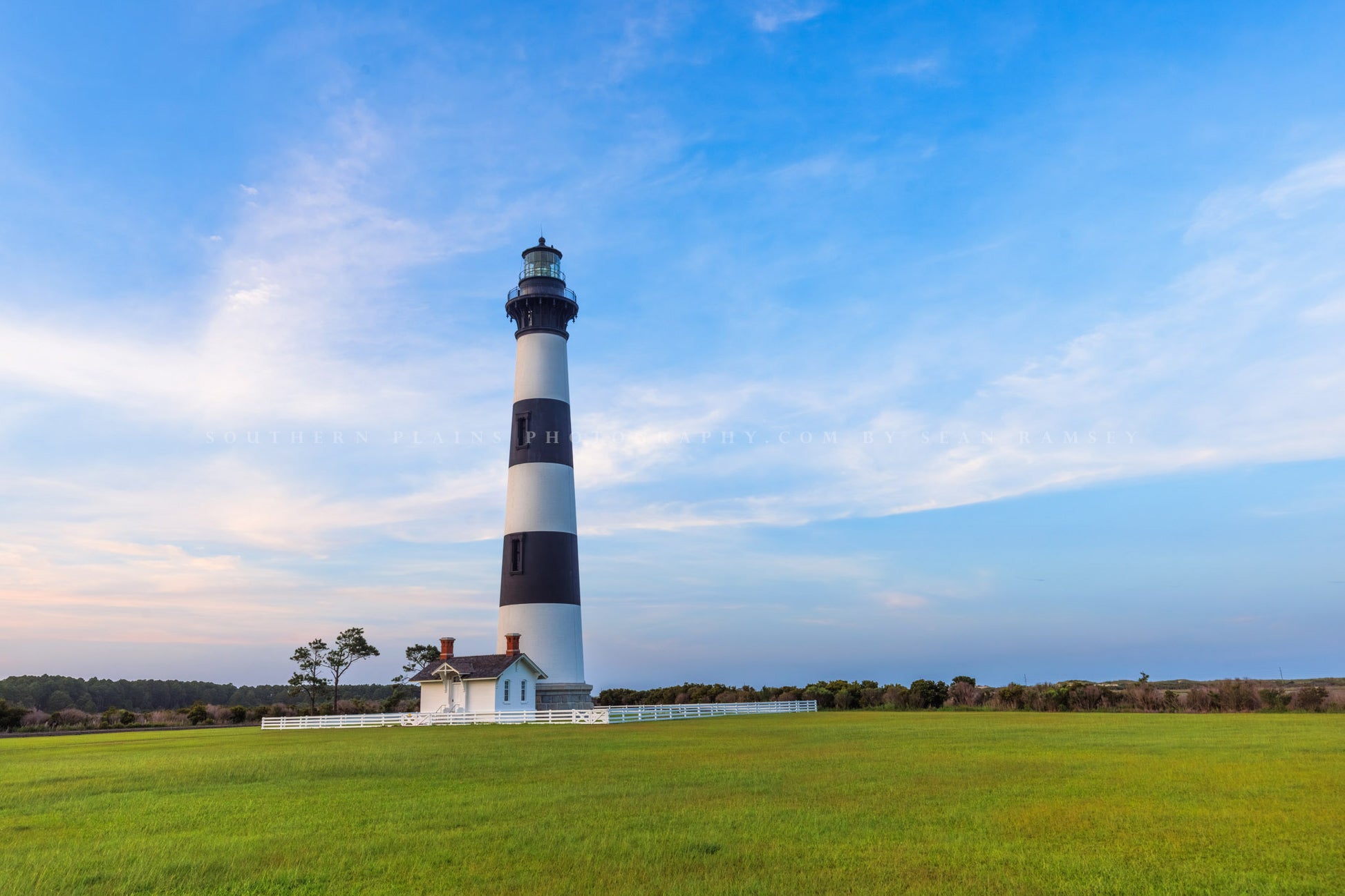 OBX photography print of the Bodie Island Lighthouse standing tall against a beautiful blue evening sky in the Outer Banks of North Carolina by Sean Ramsey of Southern Plains Photography.