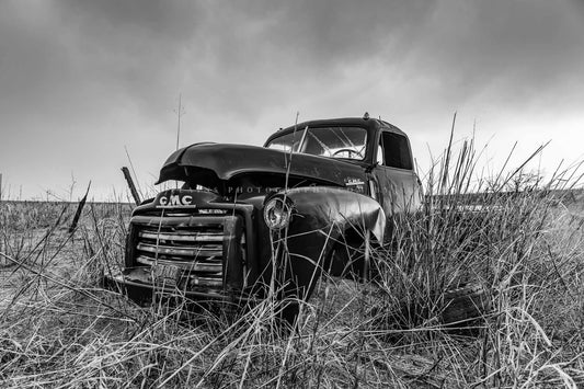 Black and white vintage style photography print of an abandoned classic pickup truck in a field on a rainy day in Oklahoma by Sean Ramsey of Southern Plains Photography.