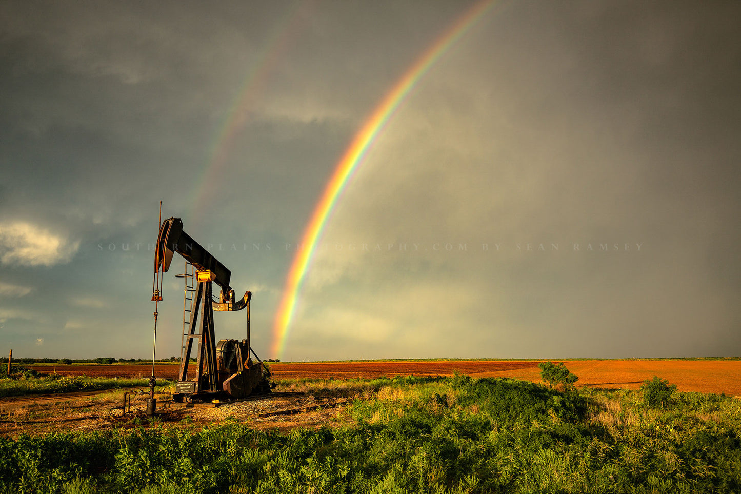 Oilfield photography print of a vibrant rainbow ending at a pump jack after a stormy day on the plains of Texas by Sean Ramsey of Southern Plains Photography.