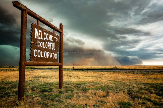 Storm photography print of a thunderstorm advancing behind a Colorful Colorado state line sign on a spring day along the Colorado and Kansas border by Sean Ramsey of Southern Plains Photography.