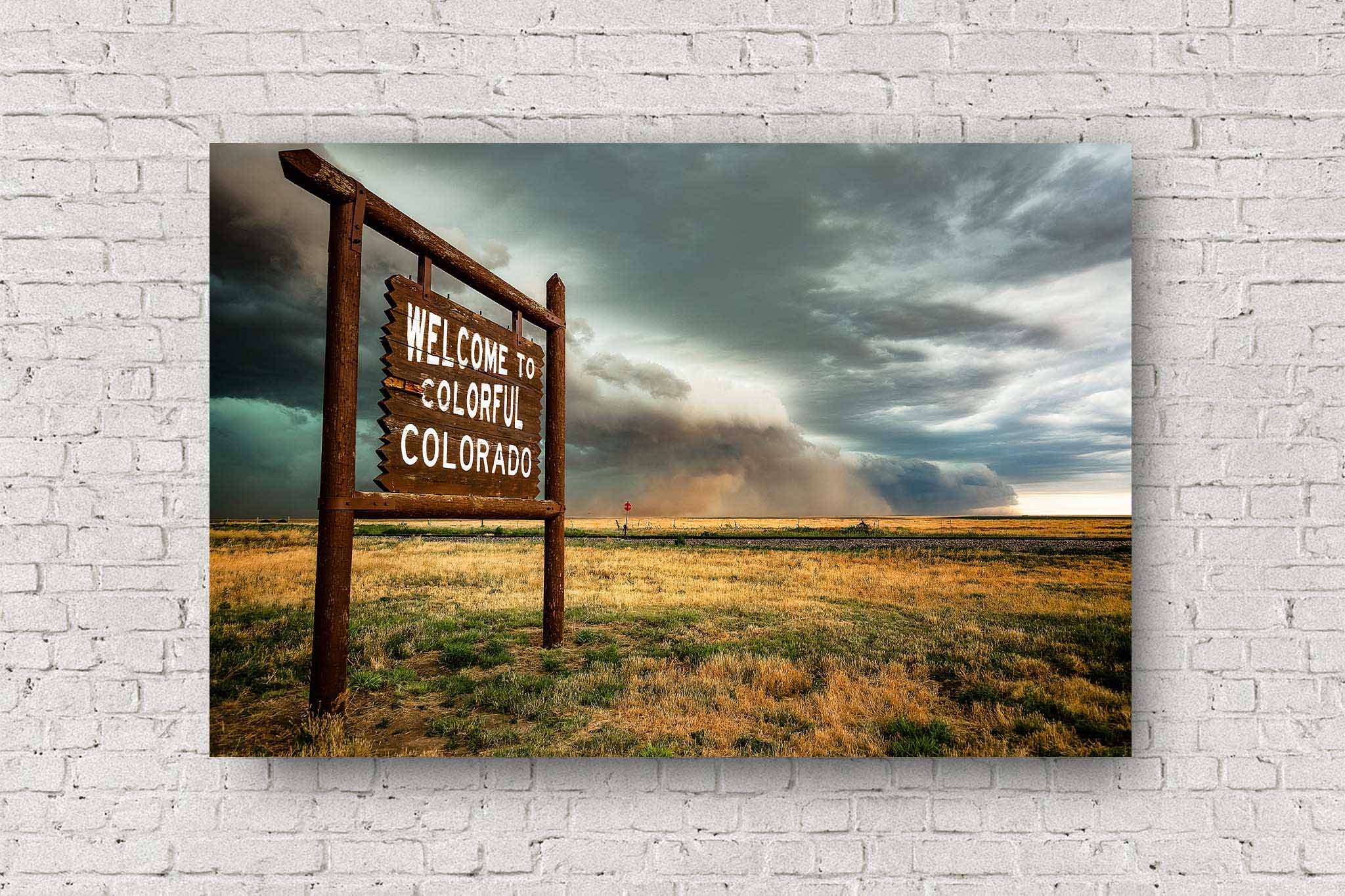 Western metal print of a storm advancing past a Colorful Colorado state line sign on a spring day along the Colorado and Kansas border by Sean Ramsey of Southern Plains Photography.