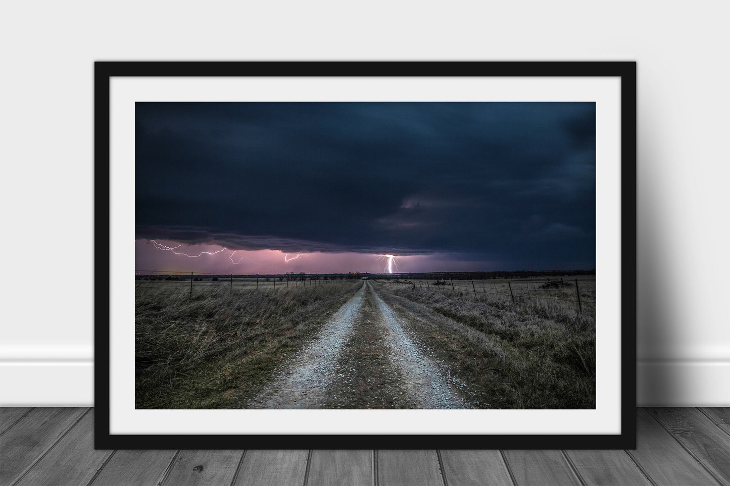 Framed and matted storm print of lightning striking down a country road on a stormy night in Kansas by Sean Ramsey of Southern Plains Photography.