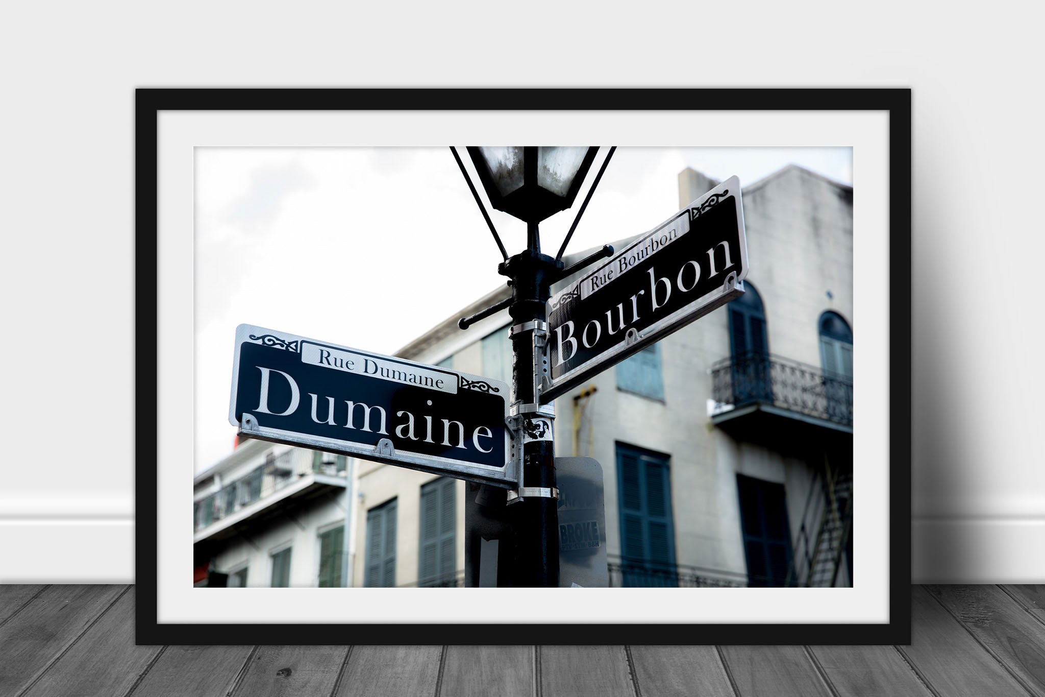 Framed and matted photography print of street signs on a lamp post at the intersection of Dumaine and Bourbon Street in the New Orleans French Quarter by Sean Ramsey of Southern Plains Photography.