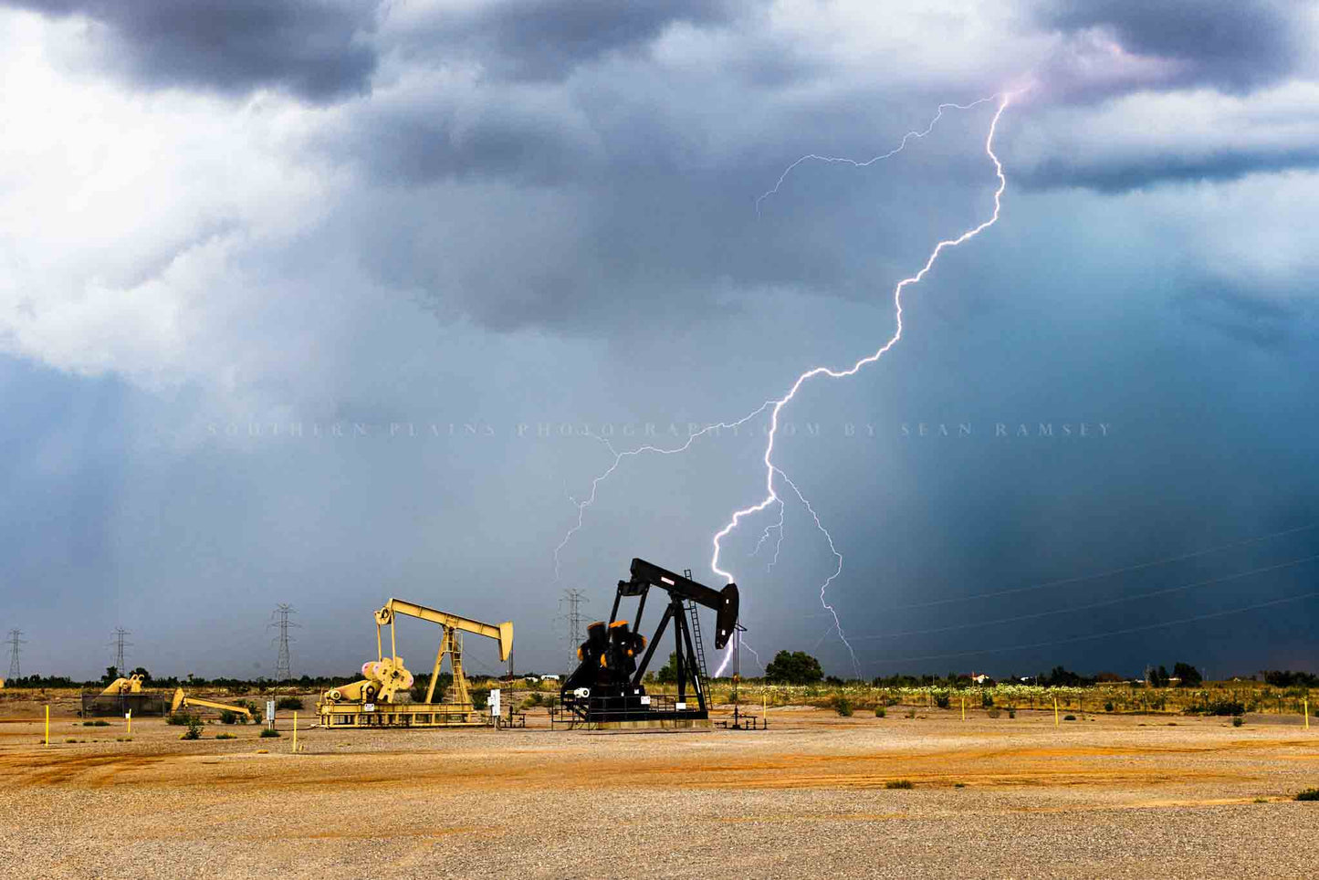Storm photography print of a lightning bolt behind pump jacks on a stormy summer day on the plains of Oklahoma by Sean Ramsey of Southern Plains Photography.