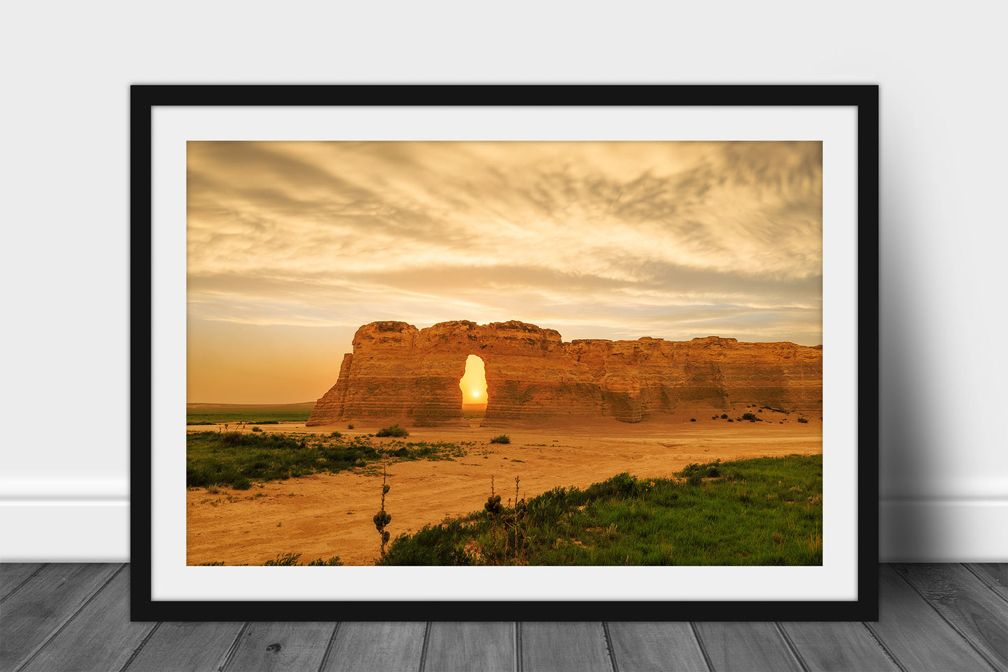 Framed Great Plains print wall art of the sun setting through an opening on a stormy evening at Monument Rocks in Kansas by Sean Ramsey of Southern Plains Photography.
