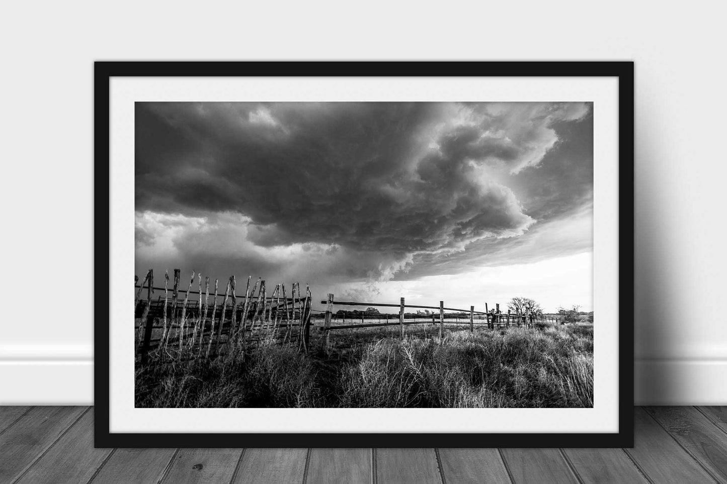 Framed storm print in black and white of a thunderstorm over an old rickety wooden fence on a stormy spring day in Oklahoma by Sean Ramsey of Southern Plains Photography.