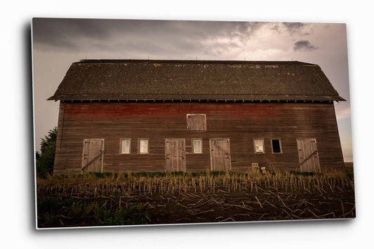 Country aluminum metal print wall art of an old red barn side with multiple doors on a stormy day in Nebraska by Sean Ramsey of Southern Plains Photography.