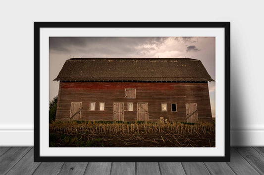 Framed country print wall art of an old red barn side with multiple doors on a stormy day in Nebraska by Sean Ramsey of Southern Plains Photography.