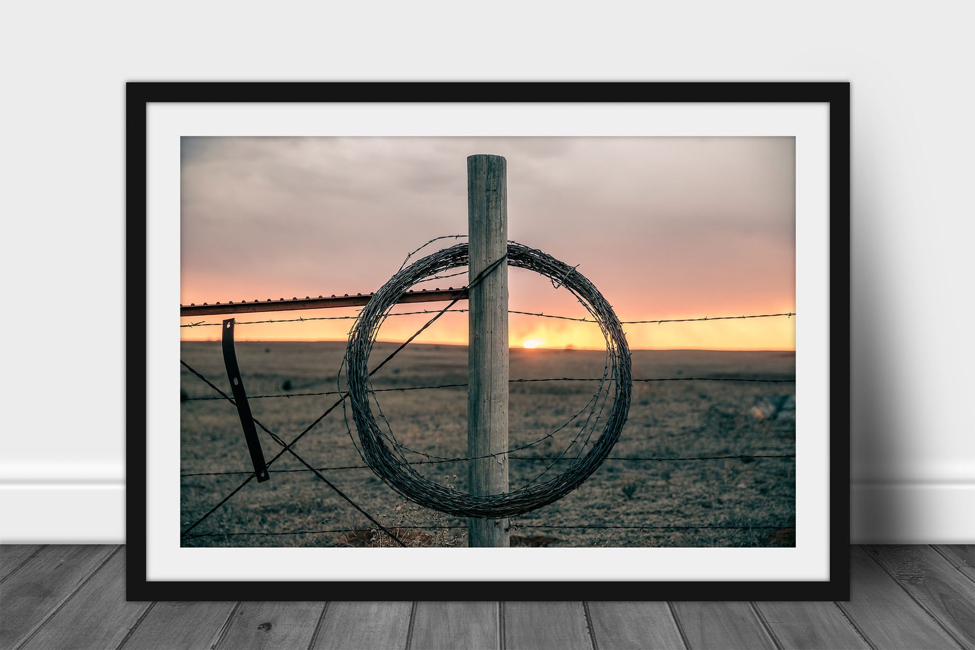 Framed and matted western print of rolled barbed wire on a fence post at sunset on a winter evening in Oklahoma by Sean Ramsey of Southern Plains Photography.
