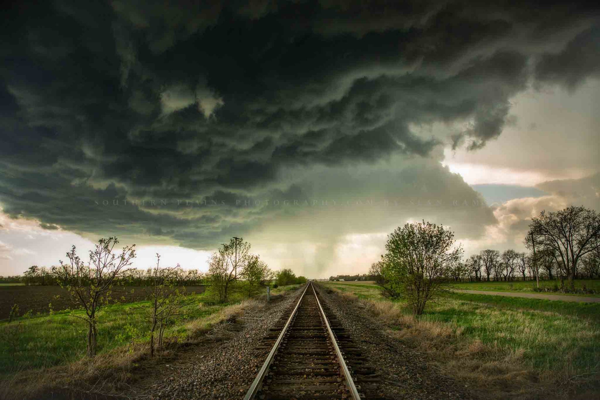 Railroad photography print of train tracks leading to dark storm clouds on a stormy spring day in Kansas by Sean Ramsey of Southern Plains Photography.