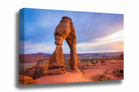 Western landscape canvas wall art of Delicate Arch glowing in evening sunlight after a rainy day in Arches National Park, Utah by Sean Ramsey of Southern Plains Photography.