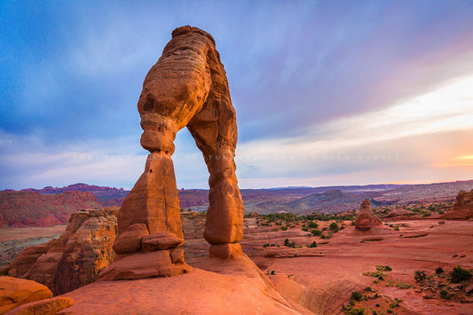 Western landscape photography print of Delicate Arch glowing in evening sunlight at sunset in Arches National Park near Moab, Utah by Sean Ramsey of Southern Plains Photography.