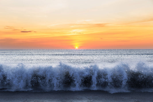 Coastal photography print of waves crashing onto a beach as the sun rises over the Atlantic Ocean on the Outer Banks in North Carolina by Sean Ramsey of Southern Plains Photography.