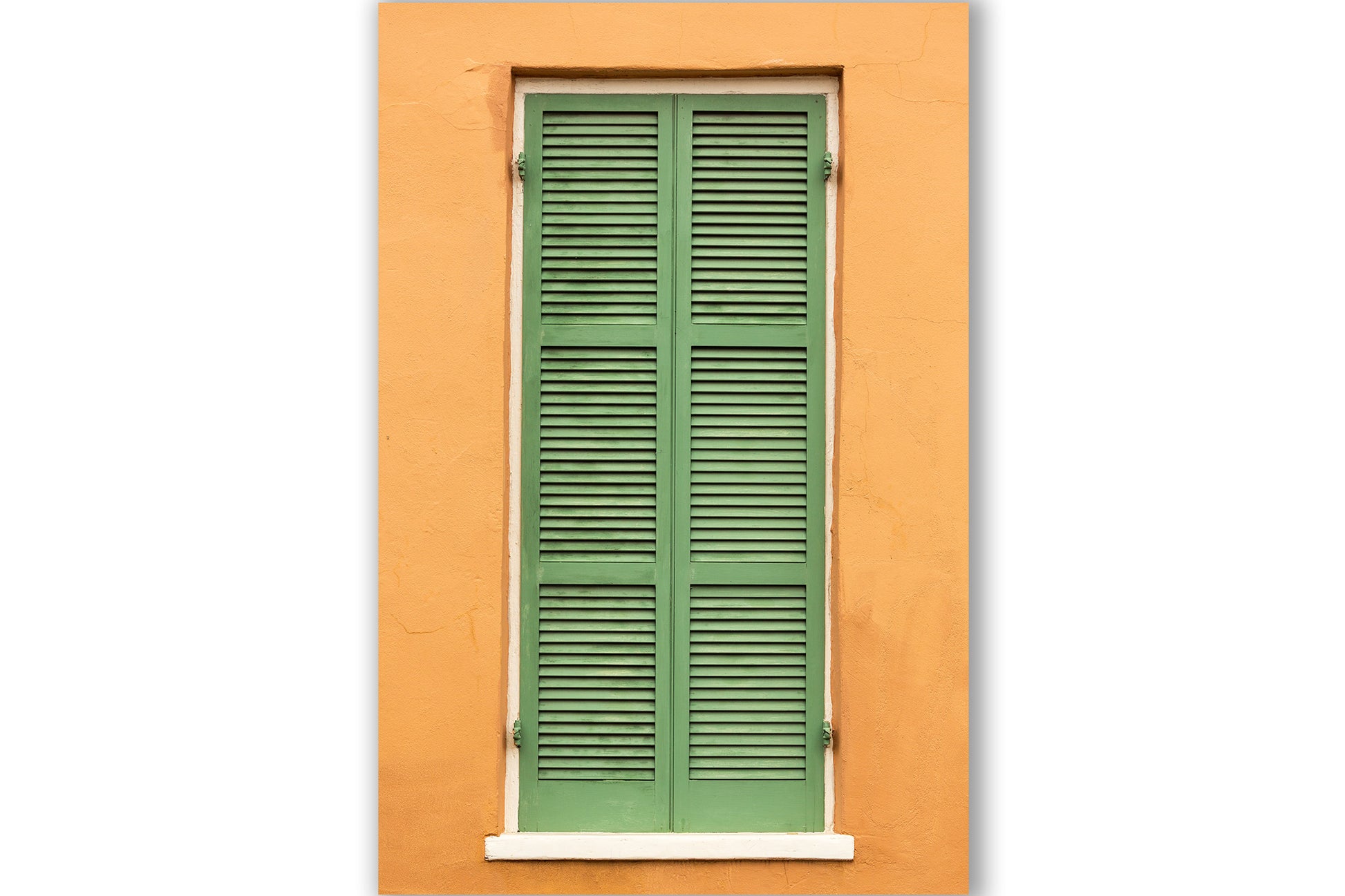Vertical NOLA photography print of green shutters against an orange wall in the French Quarter of New Orleans, Louisiana by Sean Ramsey of Southern Plains Photography.