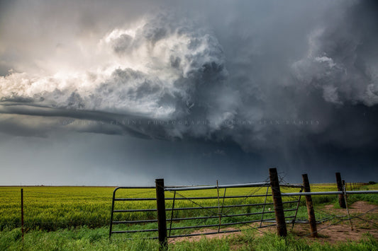 Storm photography print of a supercell thunderstorm gracefully filling the sky over a barbed wire fence and gate on a stormy spring day in Oklahoma by Sean Ramsey of Southern Plains Photography.