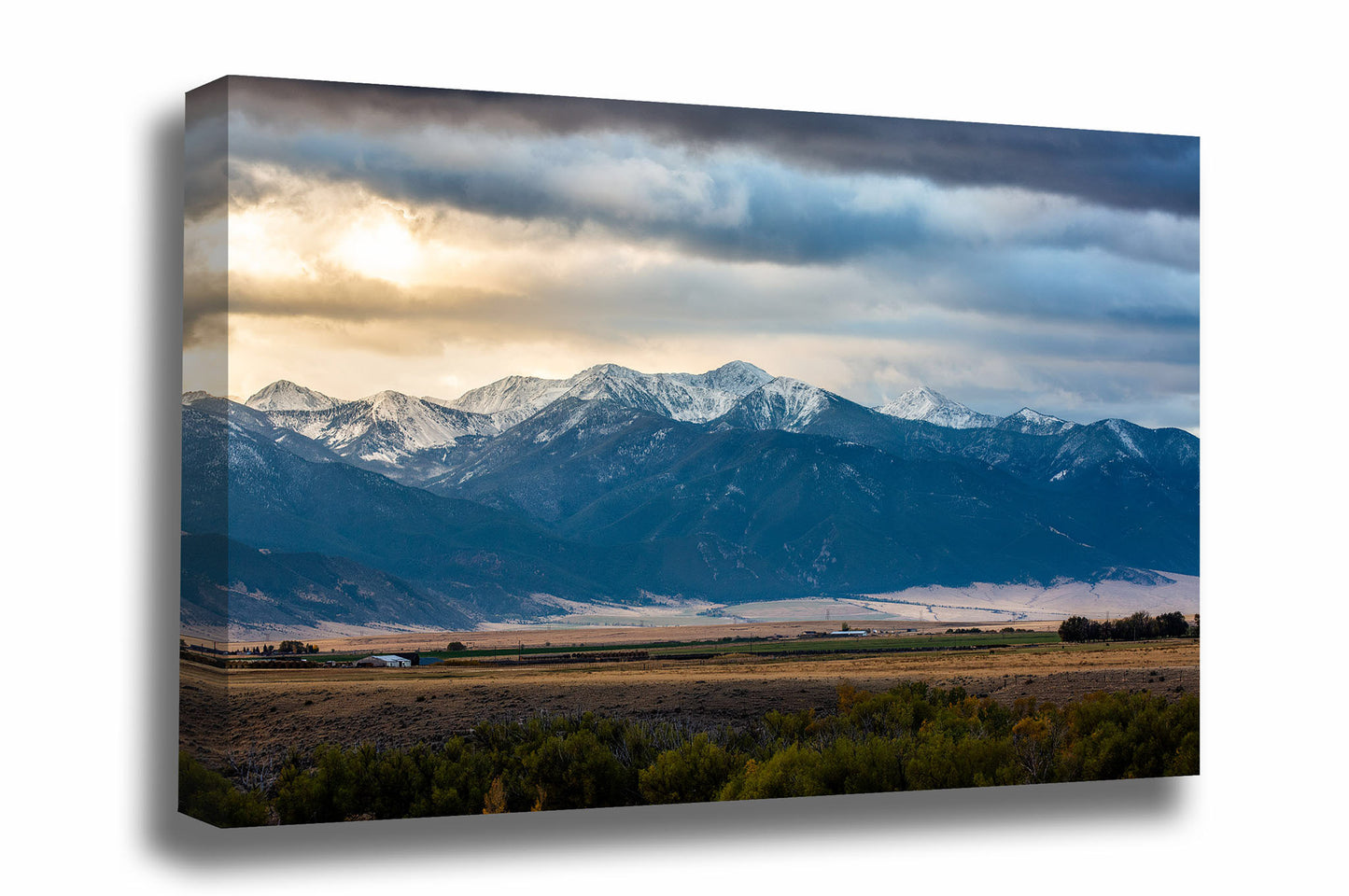 Rocky Mountains canvas wall art of snow capped peaks overlooking a valley as the sun begins to break through clouds on an autumn morning in Montana by Sean Ramsey of Southern Plains Photography.