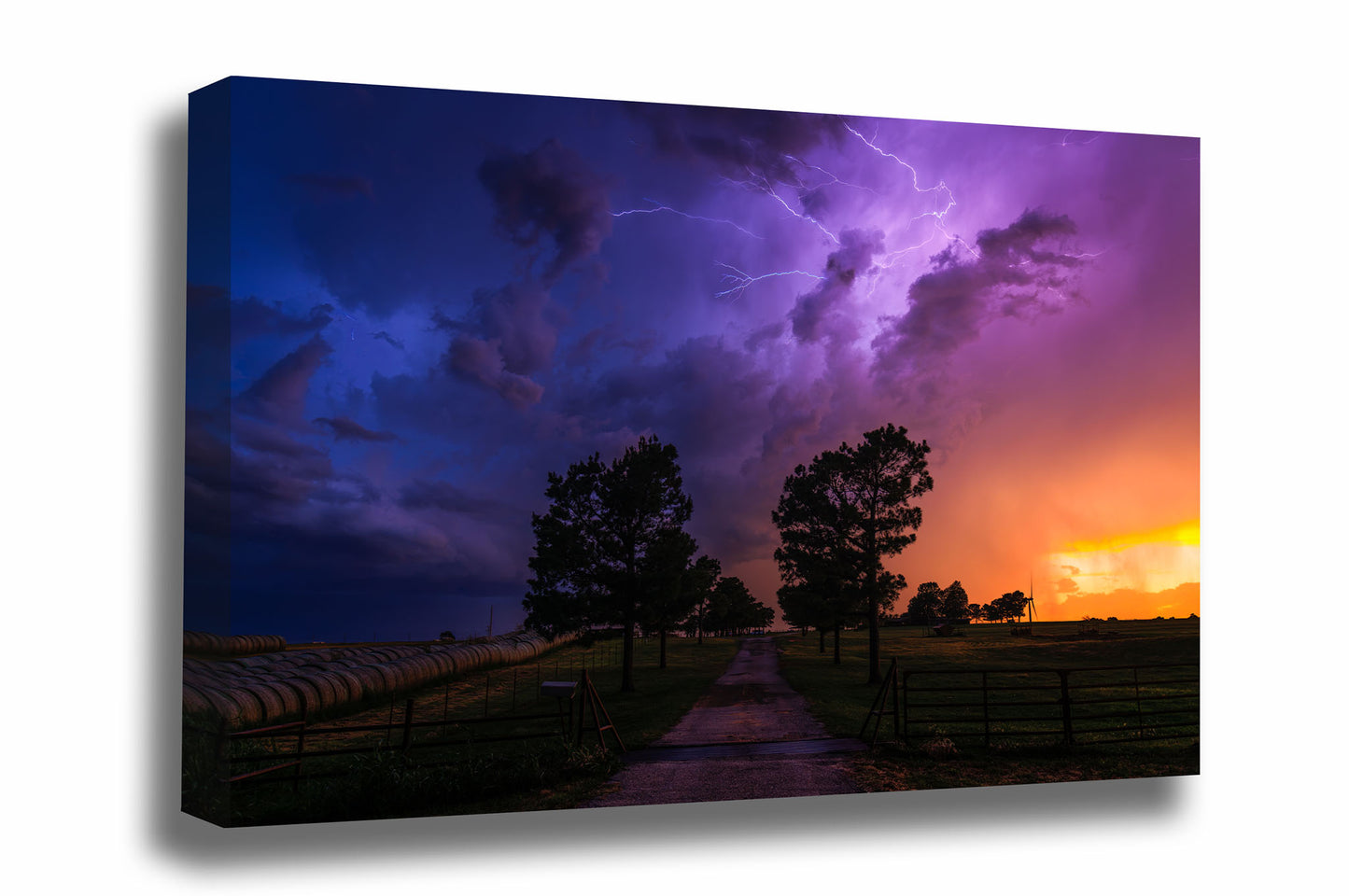 Storm gallery wrapped canvas wall art of a dramatic stormy landscape with purple and blue lightning in the sky over a rural path lined with trees at sunset on a spring evening in Oklahoma by Sean Ramsey of Southern Plains Photography.