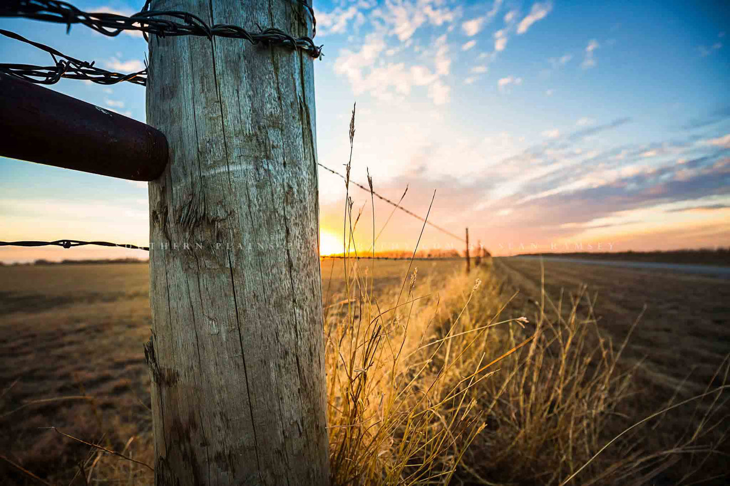 Country photography print of a fence post and prairie grass illuminated by sunlight at sunset on a chilly winter evening in Oklahoma by Sean Ramsey of Southern Plains Photography.