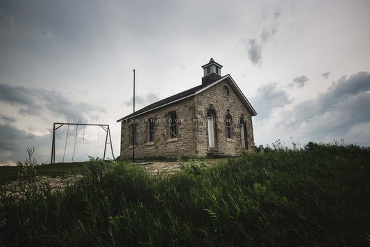 Abandoned photography print of the Lower Fox Creek school house with swing set on a stormy late spring day in the Kansas Flint Hills by Sean Ramsey of Southern Plains Photography.