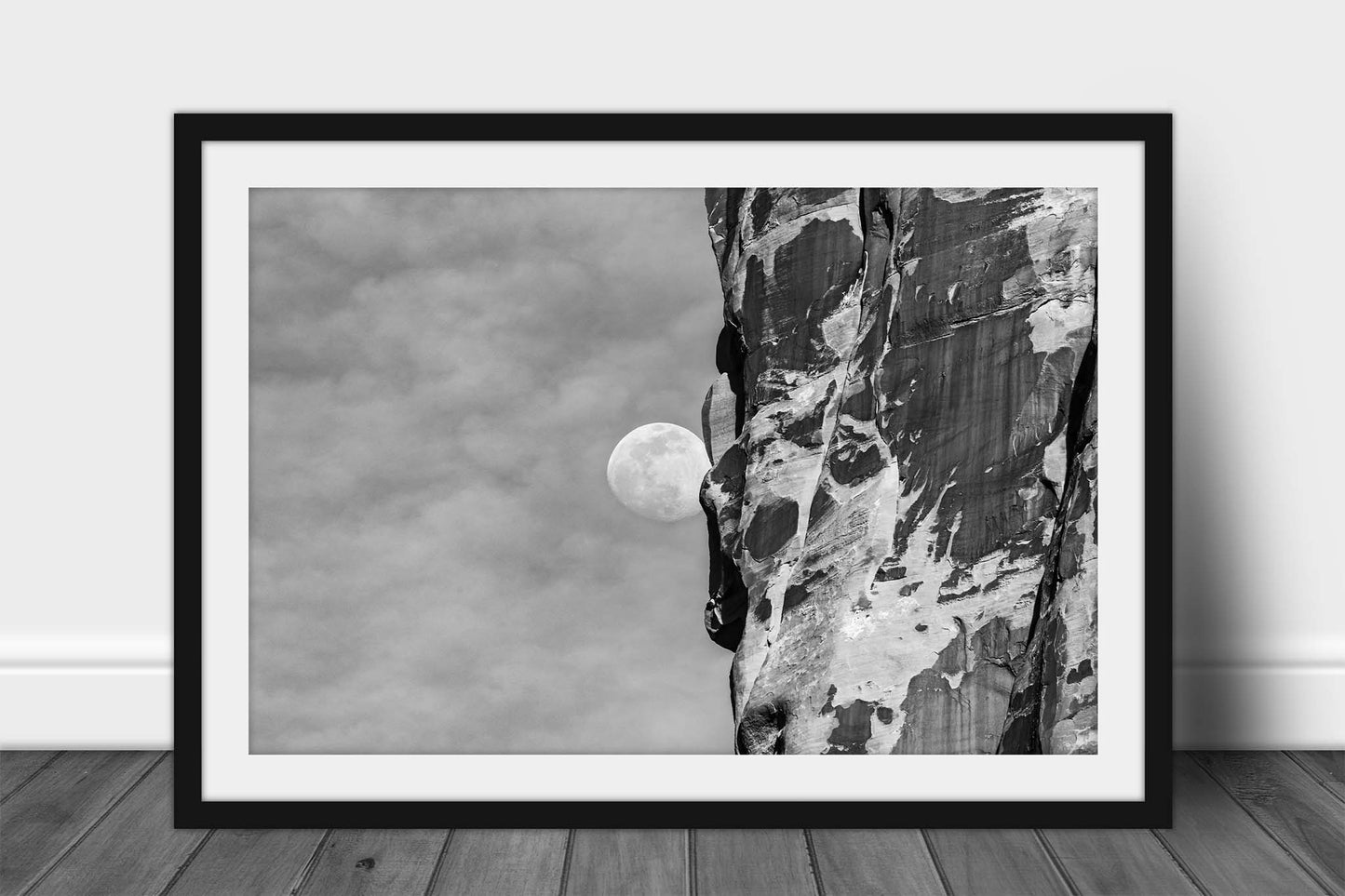 Framed black and white Southwest print of a Waning Gibbous Moon beside a sandstone cliff in Arches National Park, Utah by Sean Ramsey of Southern Plains Photography.