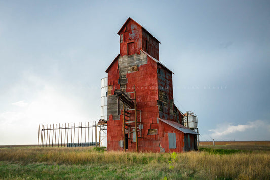 Farming photography print of an old abandoned red grain elevator standing tall on a stormy spring day on the plains of the Texas Panhandle by Sean Ramsey of Southern Plains Photography.