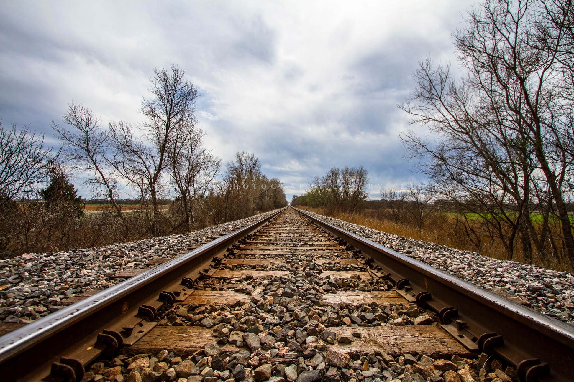 Railroad photography print of looking down train tracks and the adventures ahead on a stormy spring day in Oklahoma by Sean Ramsey of Southern Plains Photography.