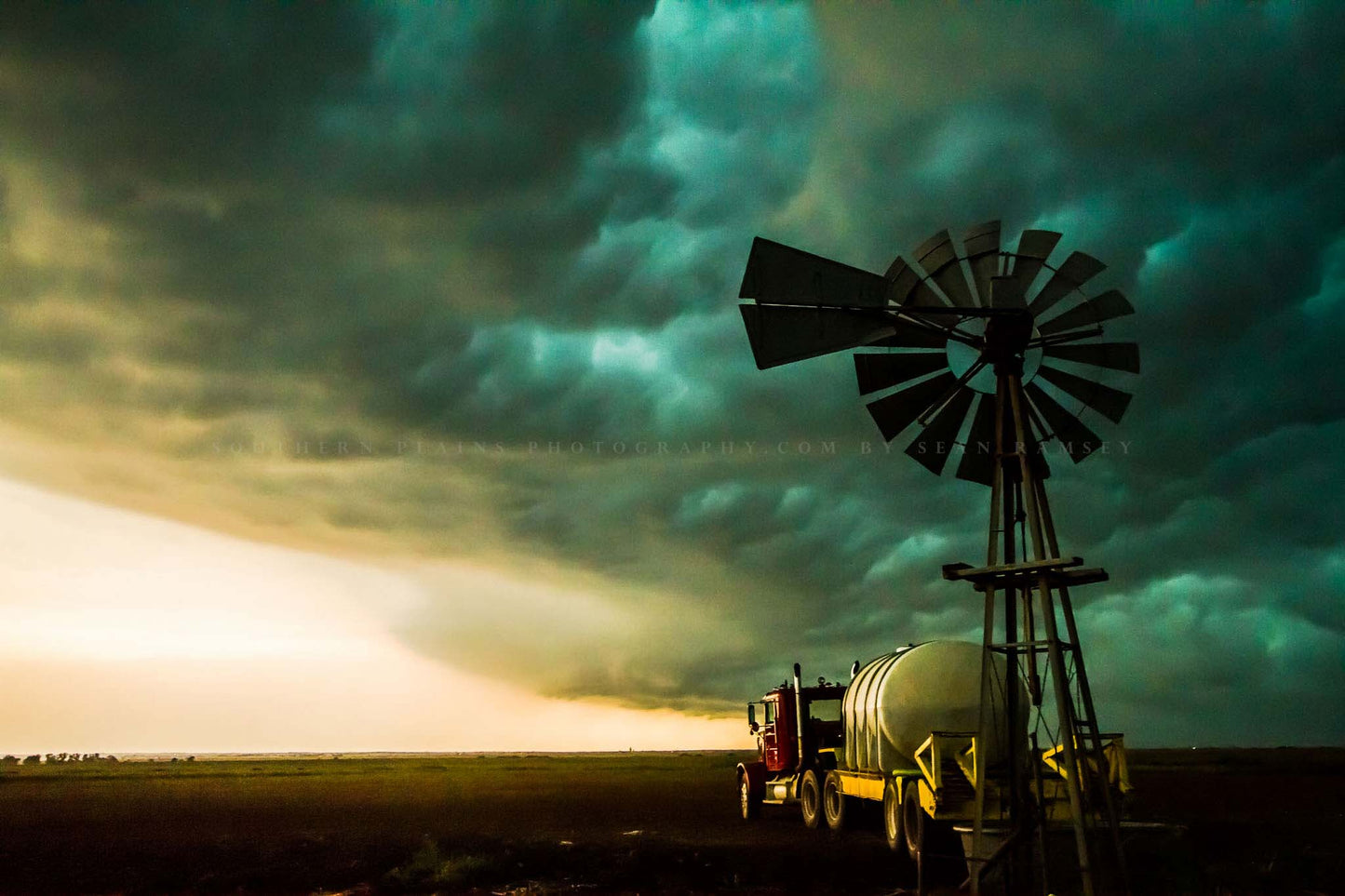 Moody country photography print of a thunderstorm advancing over an old windmill and truck on a stormy summer day on the plains of Oklahoma by Sean Ramsey of Southern Plains Photography.