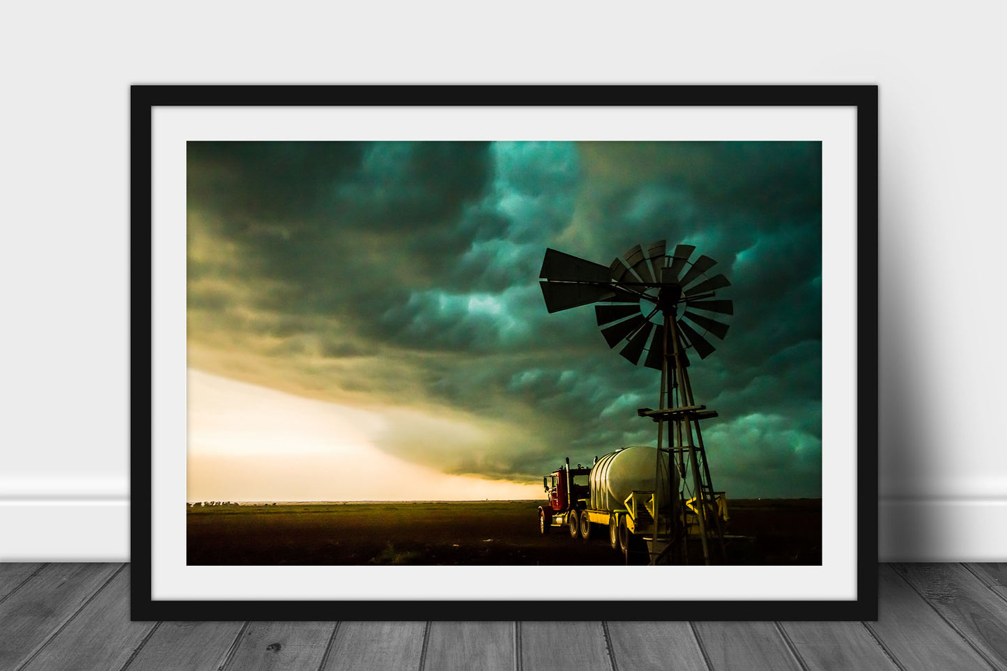 Framed and matted country photography print of an old windmill and water truck under advancing storm clouds on a stormy day on the plains of Oklahoma by Sean Ramsey of Southern Plains Photography.
