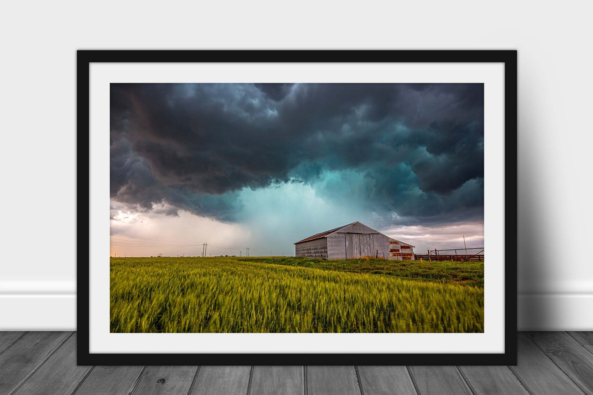 Framed country print of a storm passing behind an old tin covered barn in a wheat field on a stormy spring day in Oklahoma by Sean Ramsey of Southern Plains Photography.