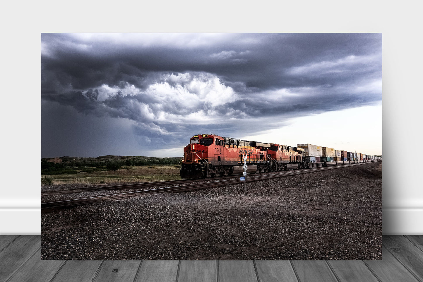Train aluminum metal print wall art of a locomotive rolling through a rural intersection and storm clouds churn above on a stormy spring day in Texas by Sean Ramsey of Southern Plains Photography.