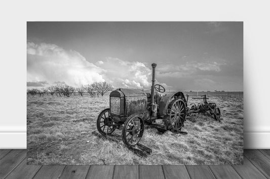Farmhouse metal print of a classic McCormick-Deering tractor sitting in a field on a stormy day in Texas in black and white by Sean Ramsey of Southern Plains Photography.