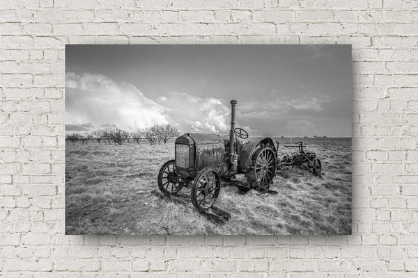 Farmhouse metal print of a classic McCormick-Deering tractor sitting in a field on a stormy day in Texas in black and white by Sean Ramsey of Southern Plains Photography.