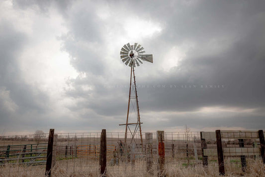 Midwestern photography print of an old windmill standing tall against a silver sky on a stormy day in Iowa by Sean Ramsey of Southern Plains Photography.