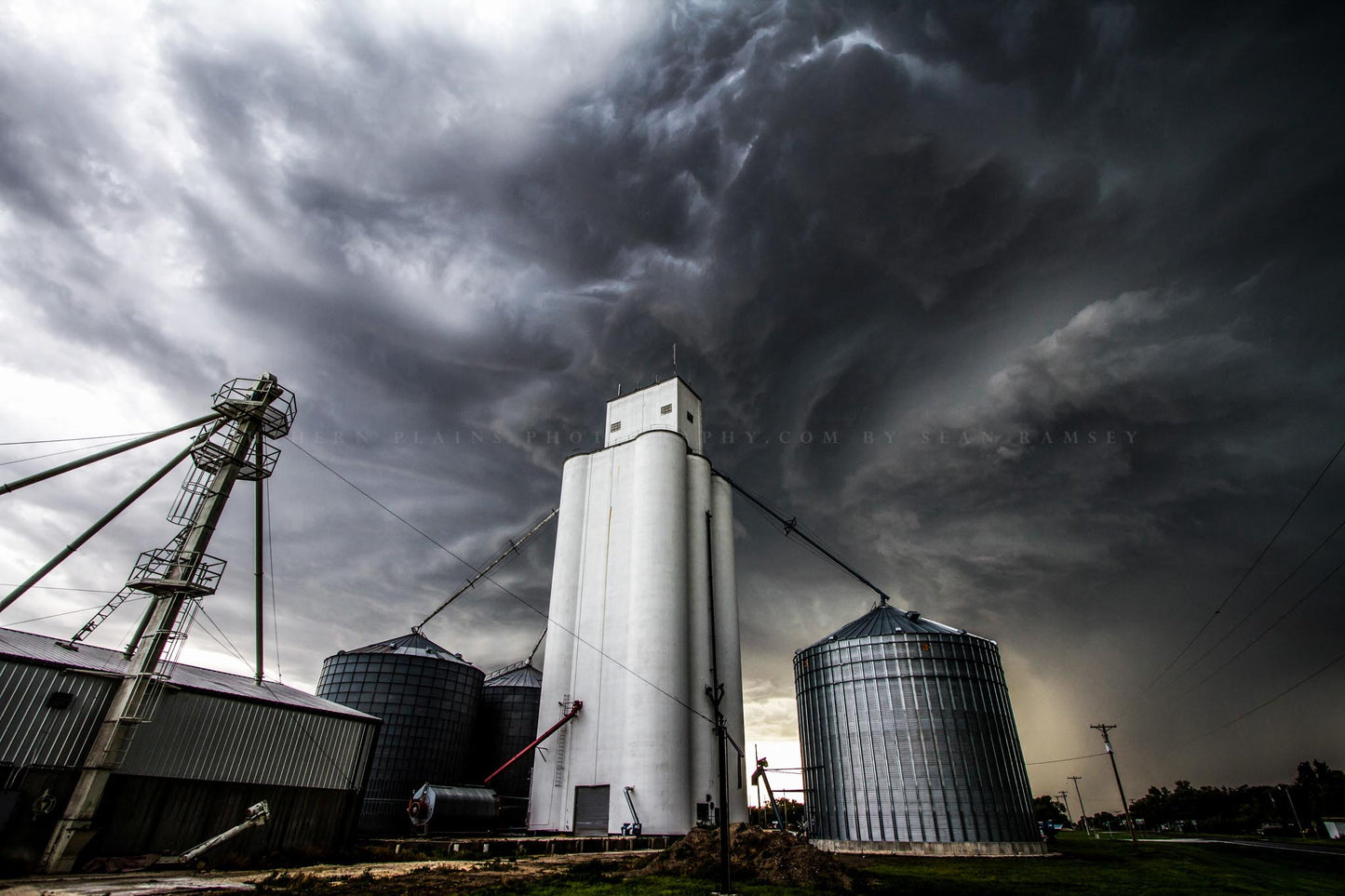 Rural photography print of storm clouds swirling over a grain elevator on a stormy spring day in a small town in Kansas by Sean Ramsey of Southern Plains Photography.