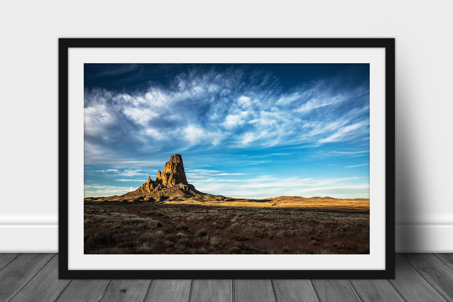 Framed western landscape print of Agathla Peak drenched in evening sunlight under big blue sky full of wispy cirrus clouds by Sean Ramsey of Southern Plains Photography.