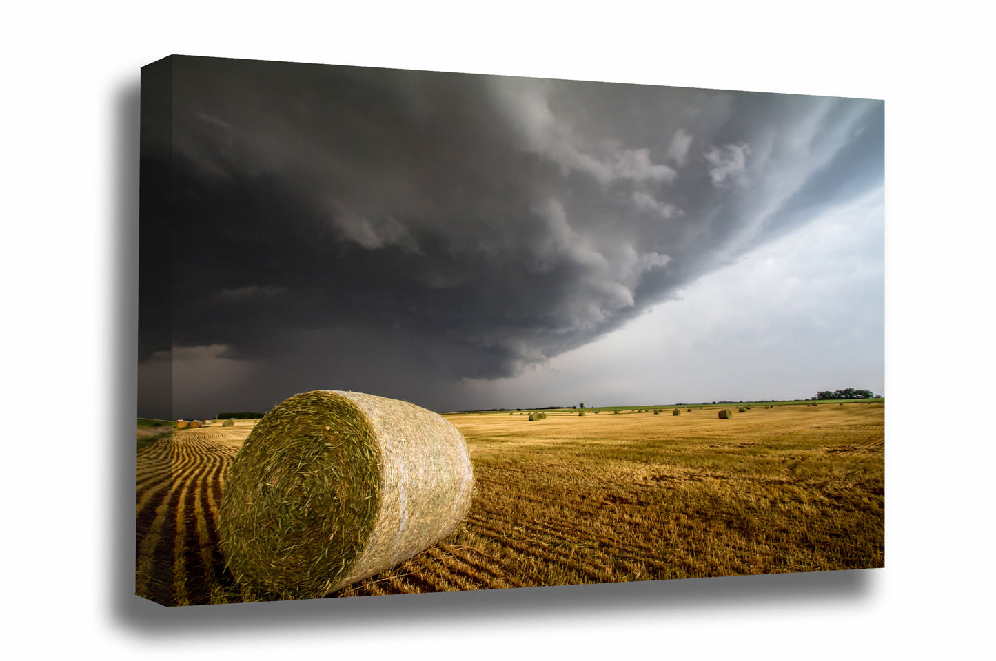 Country canvas wall art of a golden round hay bale under an advancing thunderstorm on a spring day in Kansas by Sean Ramsey of Southern Plains Photography.