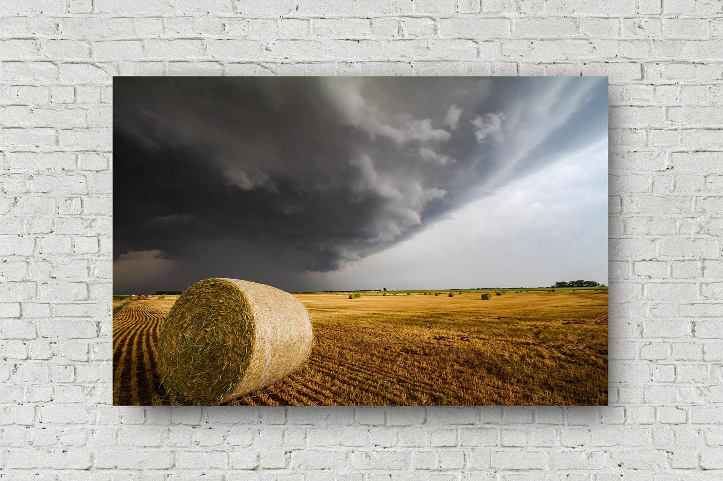 Country metal print of a storm advancing over a golden round hay bale in a field on a stormy spring day in Kansas by Sean Ramsey of Southern Plains Photography.