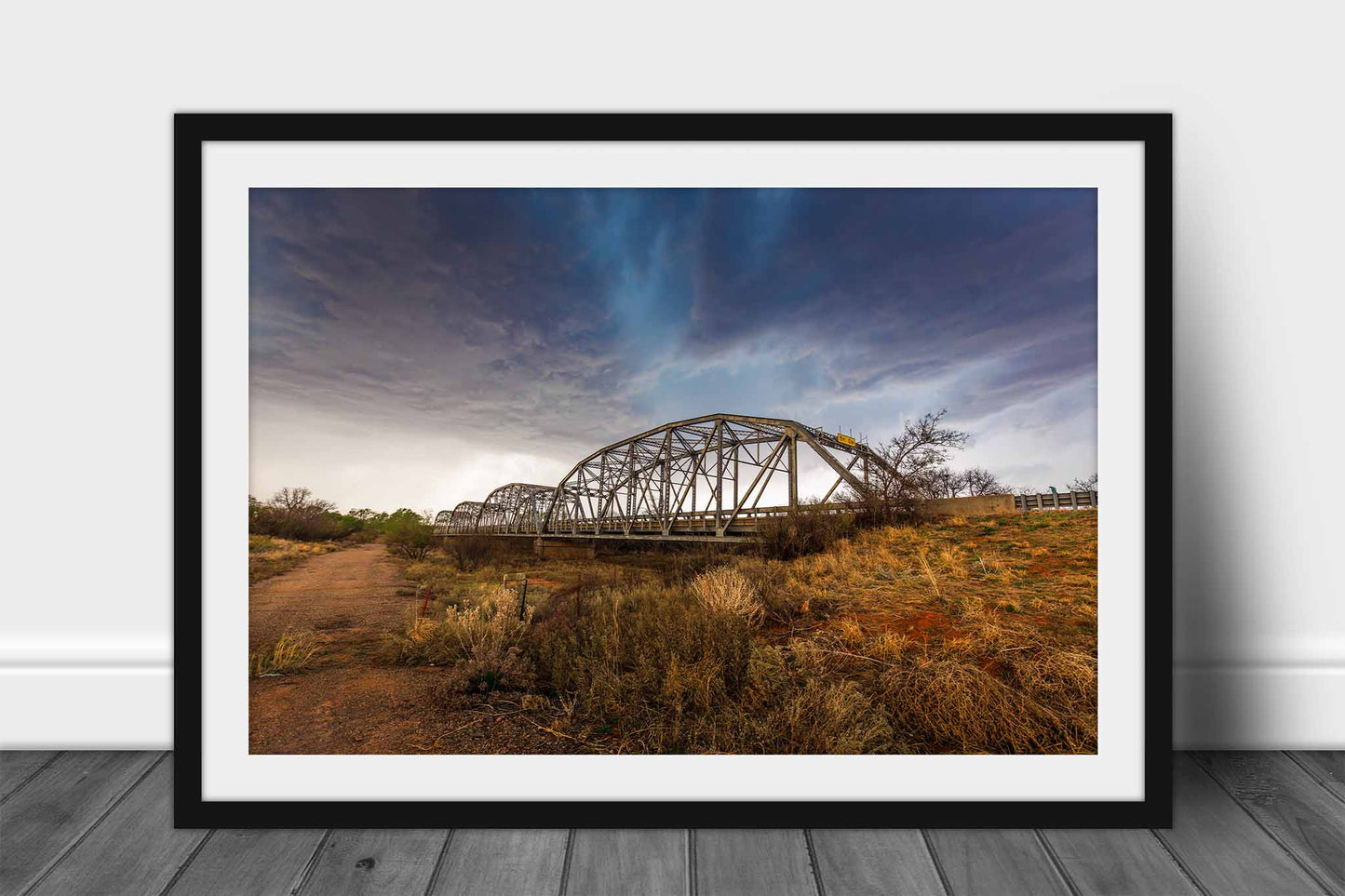 Framed storm print wall art of an aqua colored thunderstorm over and old bridge in the Texas Panhandle by Sean Ramsey of Southern Plains Photography.
