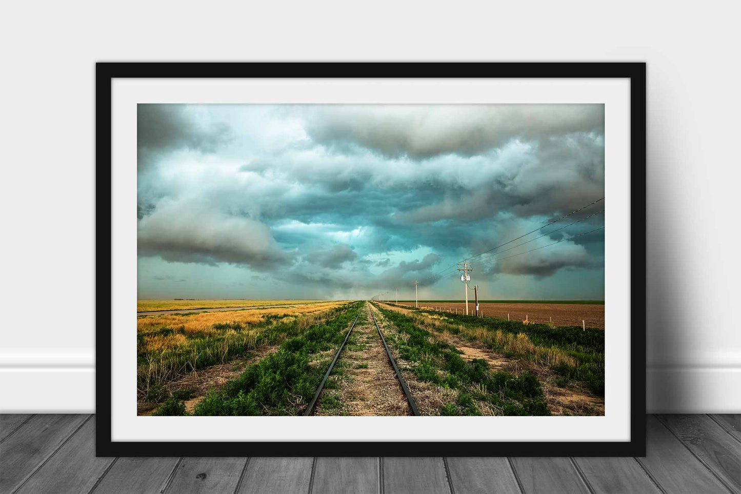 Framed railroad print of train tracks leading to a stormy sky on the plains of Colorado by Sean Ramsey of Southern Plains Photography.
