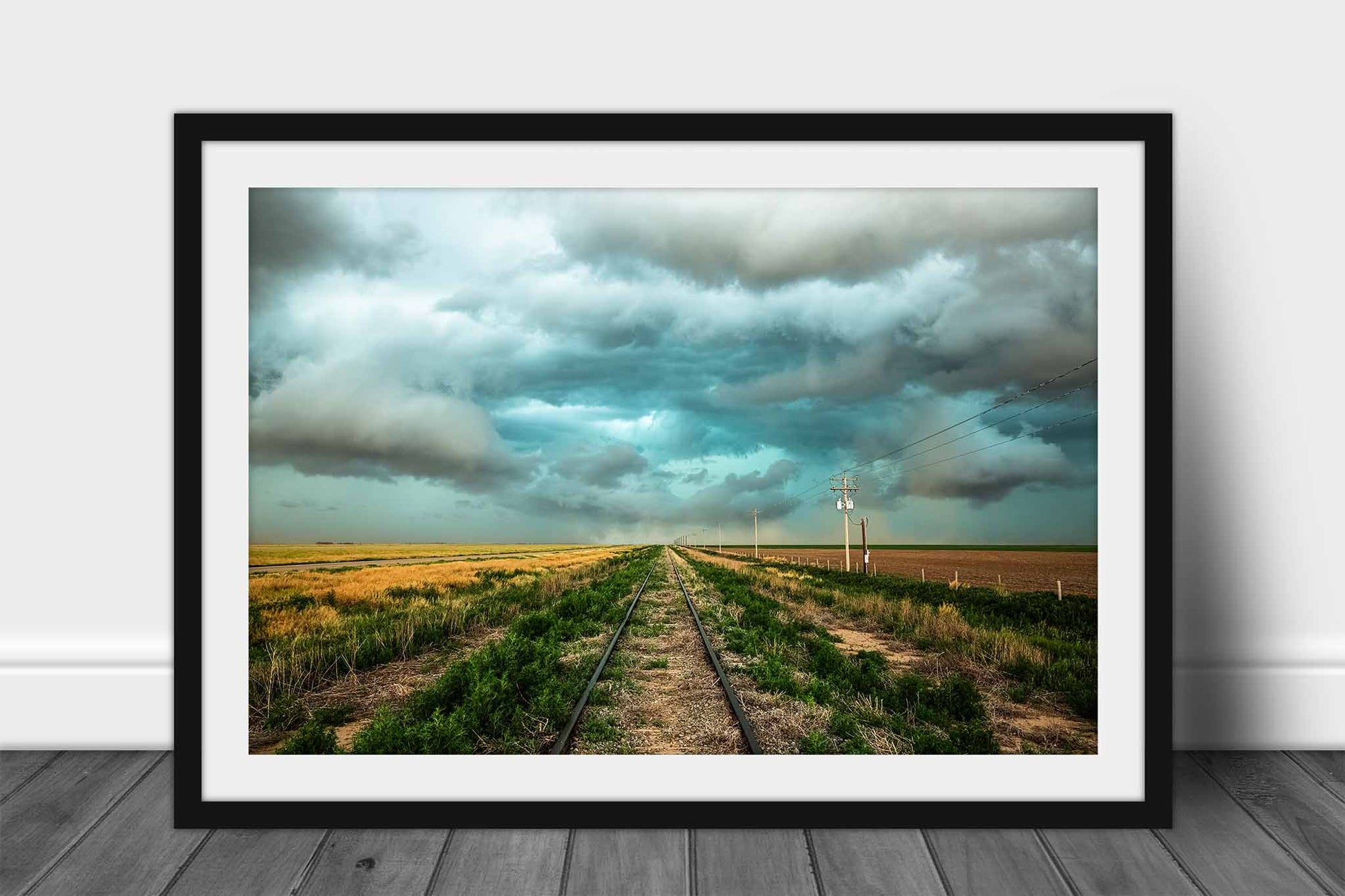 Framed railroad print of train tracks leading to a stormy sky on the plains of Colorado by Sean Ramsey of Southern Plains Photography.